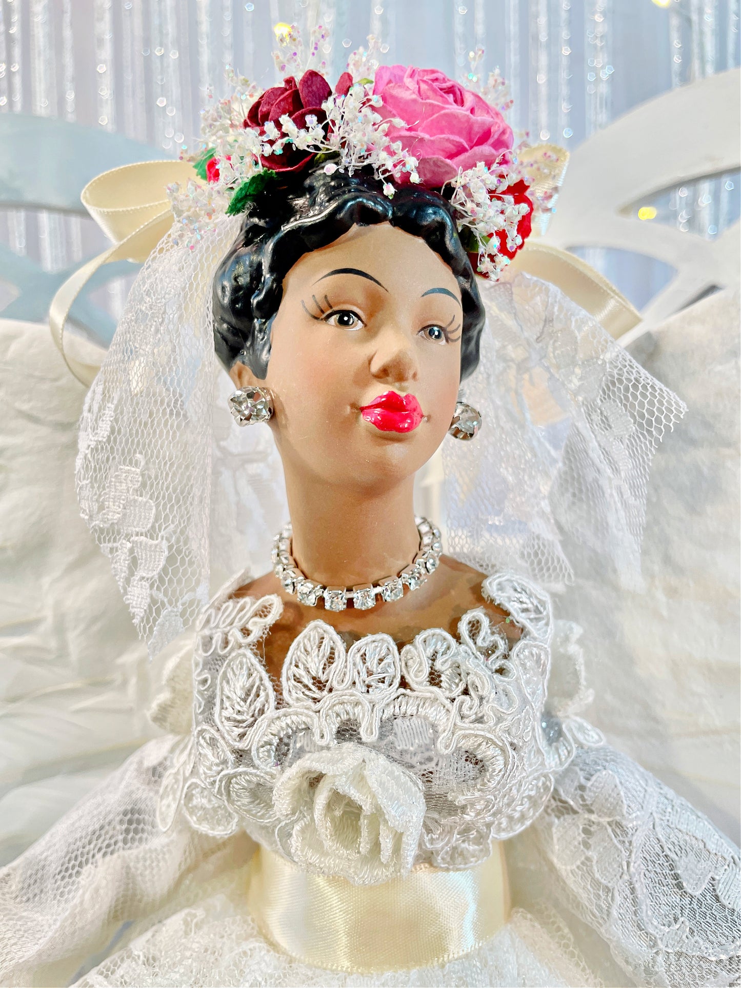 African American Christmas Angel dressed in ivory lace with red and pink floral accents close up