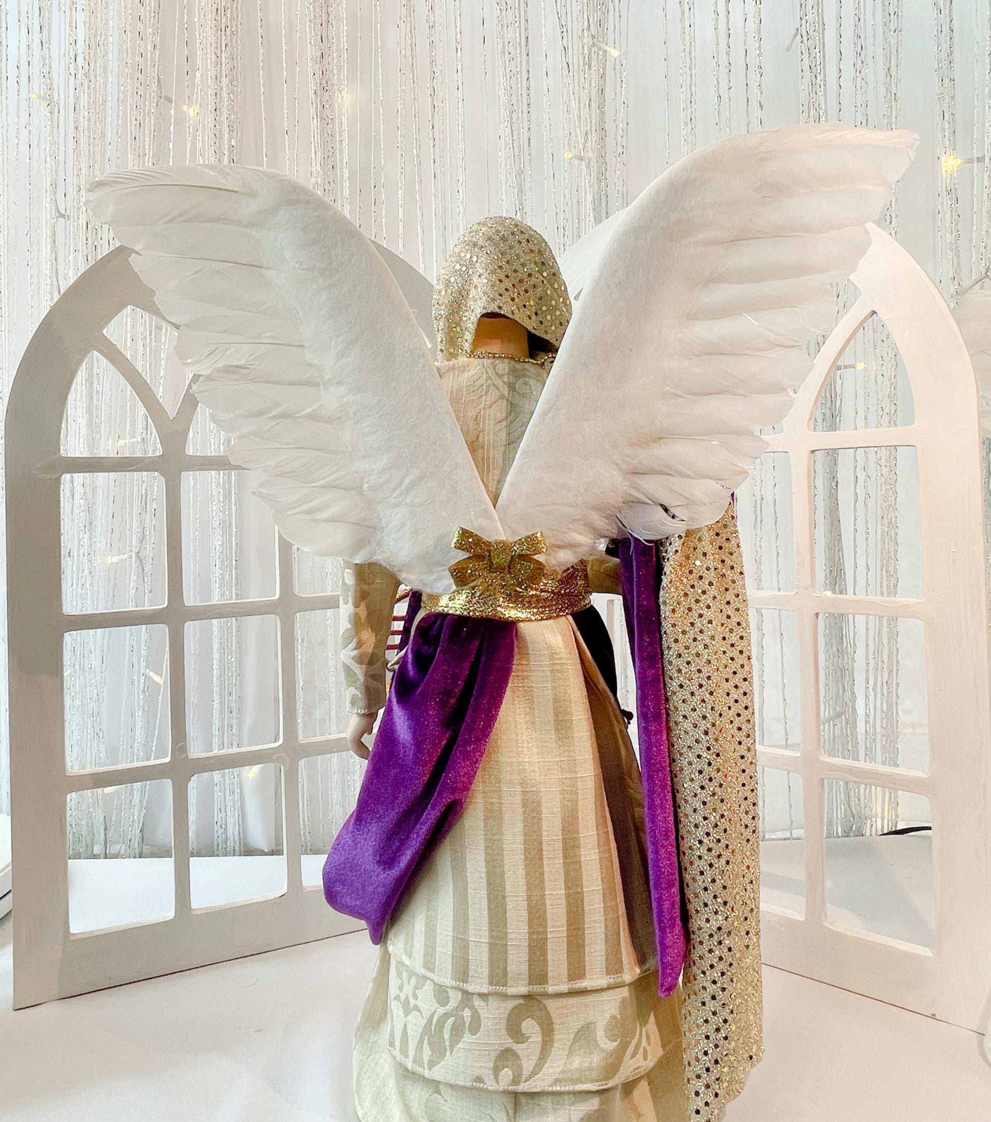 20 Inch tall Male Angel Treetopper  in Ivory, Purple and Gold, he has a horn at his side, a Bible in his arm, a cross on his shoulder and a metal plate at the waist that says courage BACK VIEW