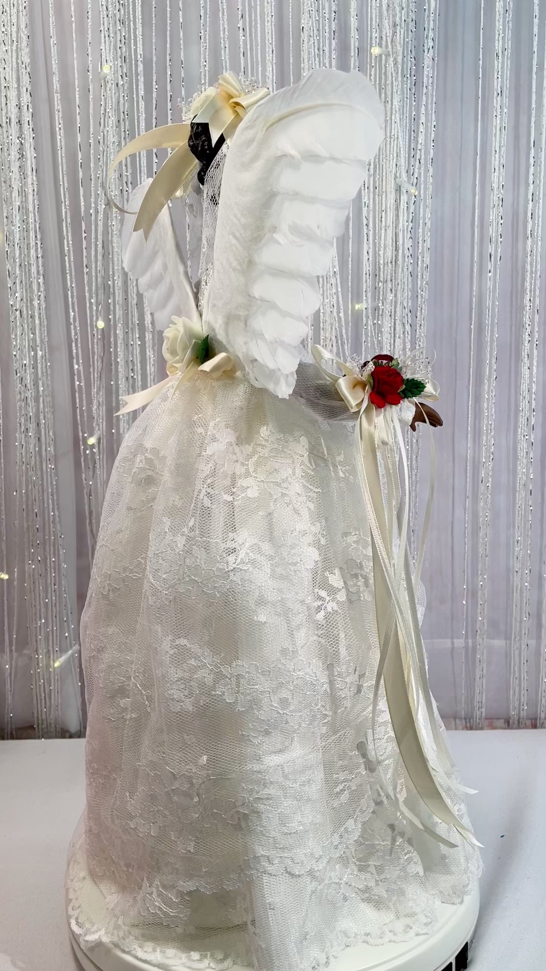 Video of an African American 18 inch tall Christmas Angel dressed in an ivory lace gown with red floral accents.